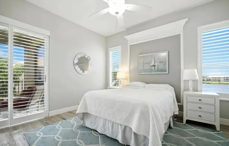 Bedroom featuring wood finished floors, multiple windows, and ceiling fan
