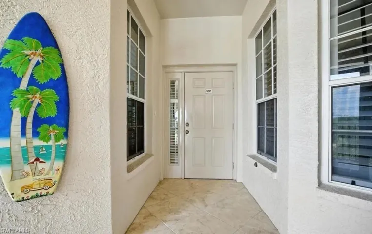 View of exterior entry with stucco siding and covered porch
