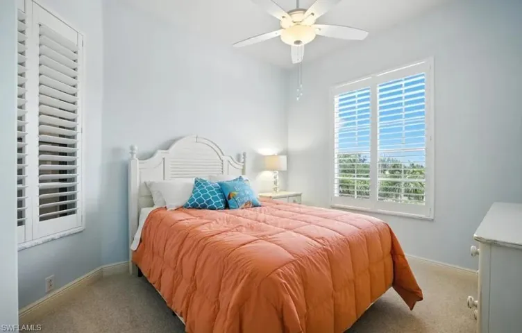 Carpeted bedroom featuring a ceiling fan and baseboards