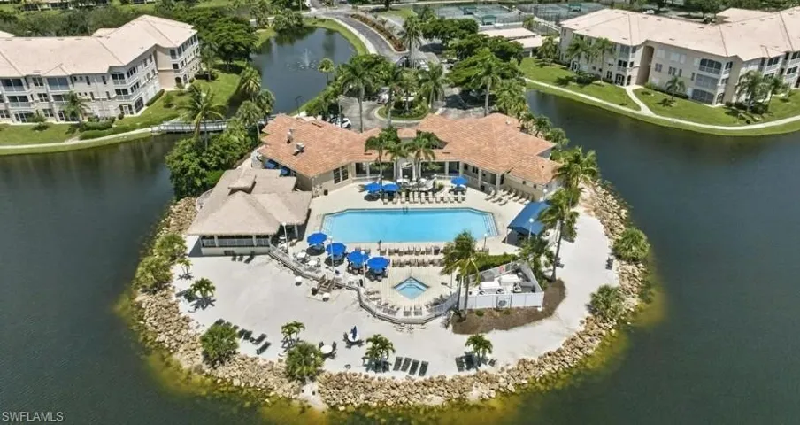 Drone / aerial view of a nearby body of water and a pool area