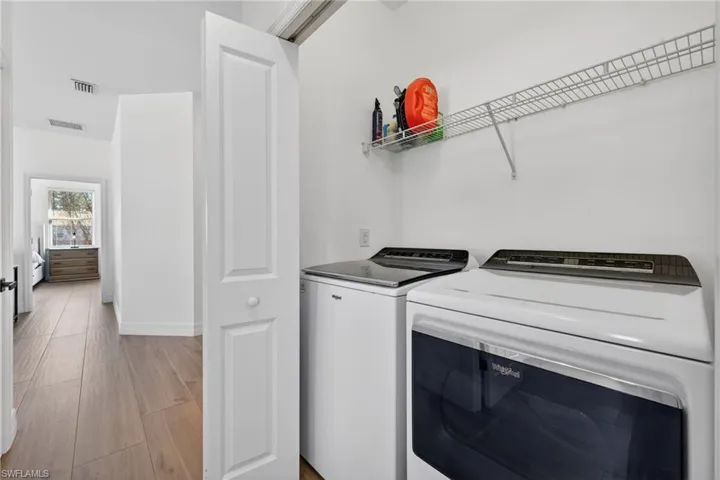 Laundry area with light wood finished floors and separate washer and dryer