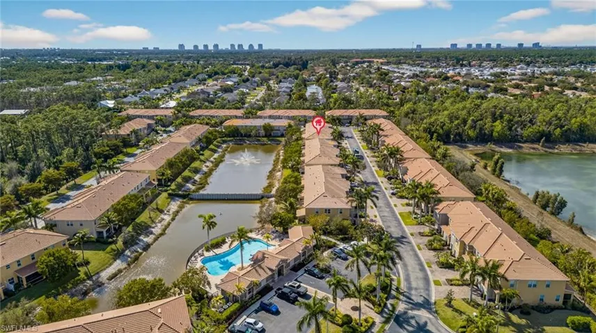 Aerial perspective of suburban area with a nearby body of water and city skyline