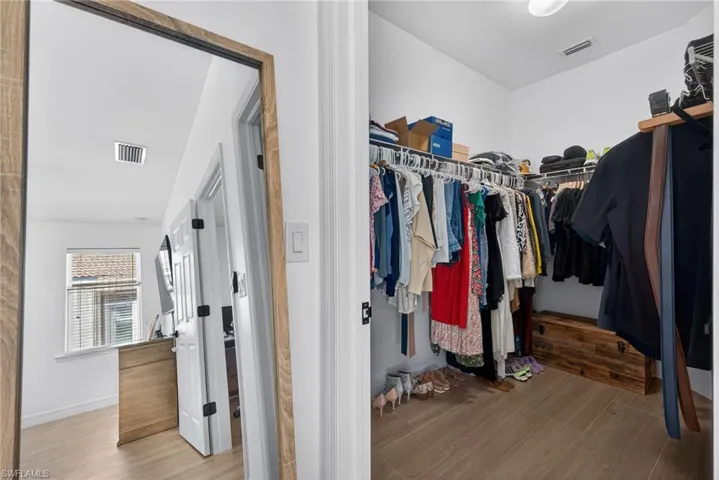 Walk in closet with light wood-style flooring