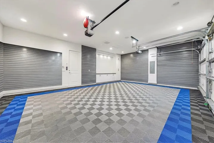 Garage featuring electric panel and recessed lighting