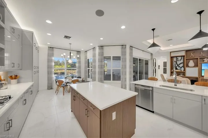 Kitchen with decorative light fixtures, modern cabinets, dishwasher, a center island, and recessed lighting