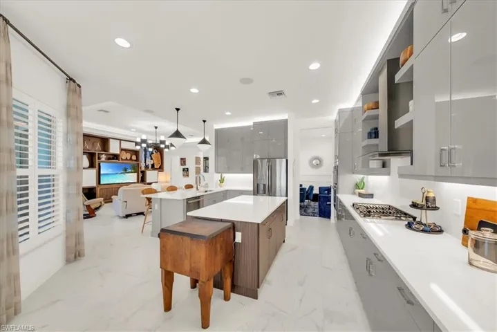 Kitchen with modern cabinets, gray cabinetry, a peninsula, pendant lighting, and recessed lighting