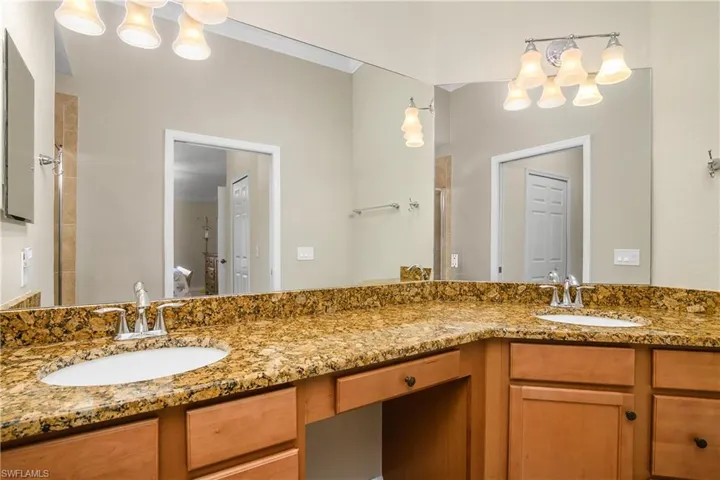 Primary bathroom features Dual Sinks, a large vanity, and walk-in shower