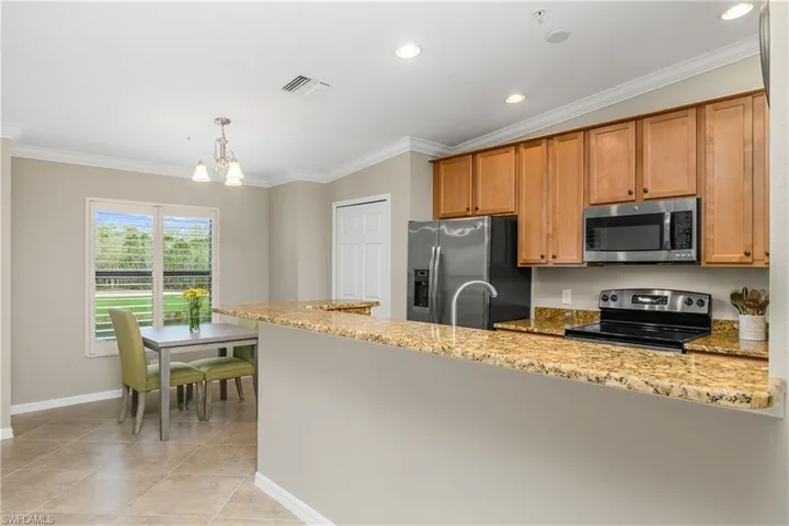 Kitchen is spacious and features granite countertops, stainless steel appliances, a large pantry for additional storage, and a cafe nook area which overlooks the water and golf course beyond.