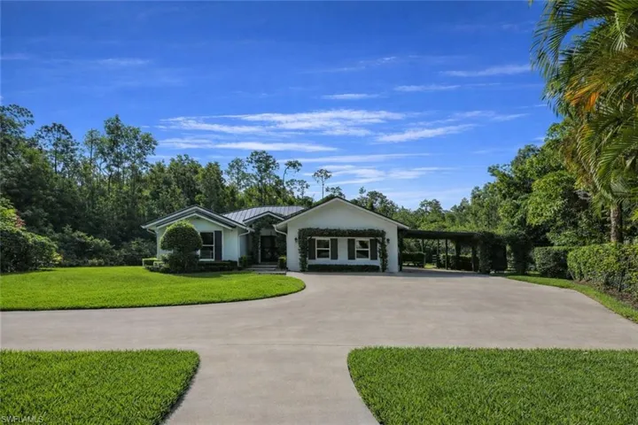 View of community with curved driveway and a lawn