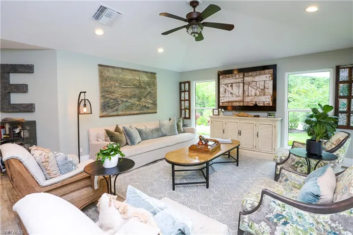 Living area with recessed lighting, lofted ceiling, ceiling fan, and wood finished floors