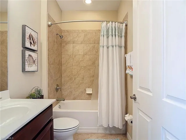 Full bathroom featuring tile patterned floors, toilet, shower / tub combo, and vanity