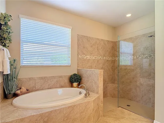 Bathroom featuring independent shower and bath and tile patterned flooring