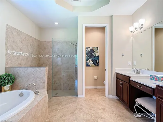 Full bathroom featuring tile patterned floors, independent shower and bath, toilet, and vanity