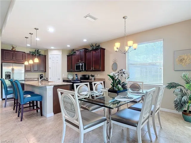 Dining room with light tile patterned floors and an inviting chandelier