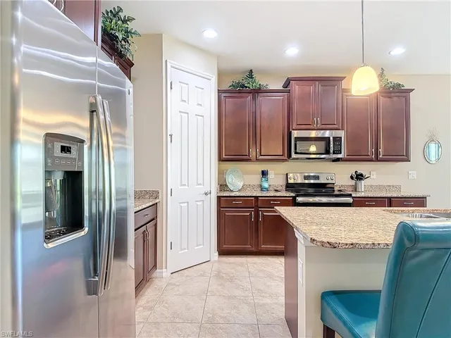 Kitchen featuring pendant lighting, a breakfast bar, stainless steel appliances, sink, and light tile patterned flooring