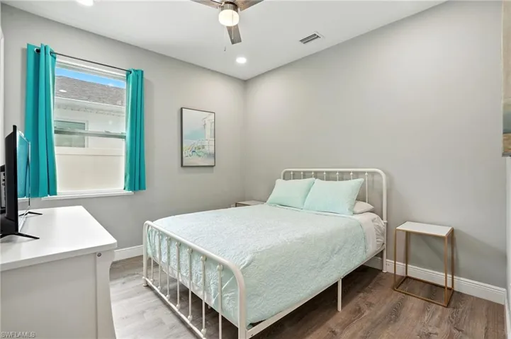 Bedroom with wood finished floors, a ceiling fan, and recessed lighting