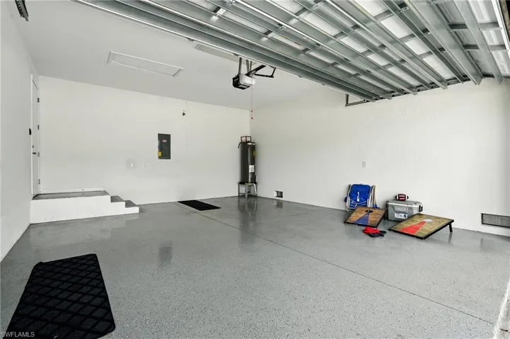 Garage featuring electric panel and water heater