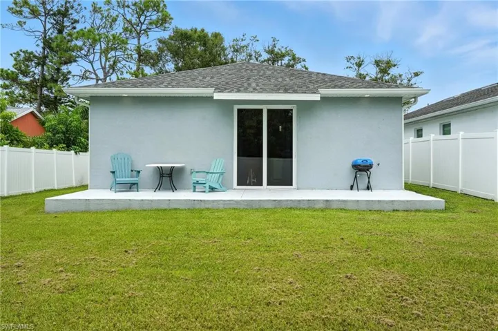 Rear view of house with a patio, roof with shingles, and stucco siding