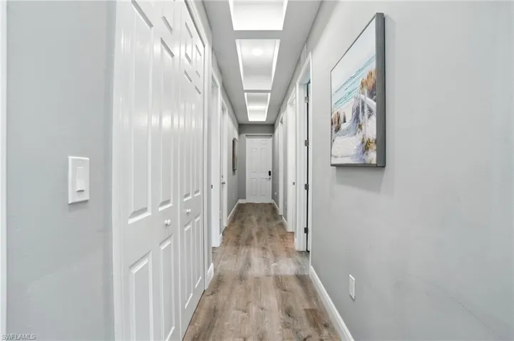 Hallway with light wood-style flooring and recessed lighting
