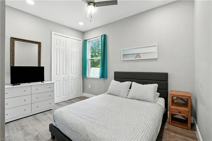 Bedroom with light wood-style floors, a ceiling fan, a closet, and recessed lighting