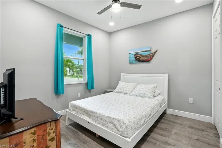 Bedroom with wood finished floors, ceiling fan, a closet, and recessed lighting