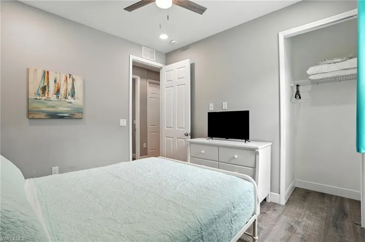 Bedroom featuring wood finished floors, a closet, and a ceiling fan