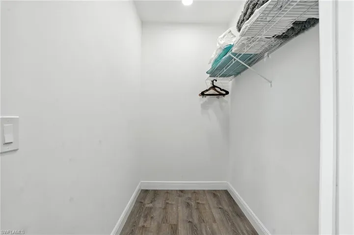 Walk in closet featuring dark wood-type flooring