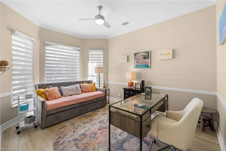 Living room with ceiling fan, light hardwood / wood-style floors, and ornamental molding