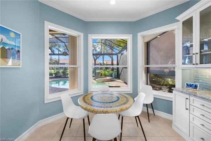Dining area with light tile patterned floors and ornamental molding