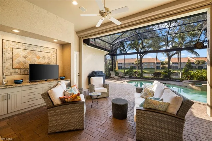 View of patio / terrace with area for grilling, an outdoor living space, ceiling fan, sink, and a swimming pool with hot tub