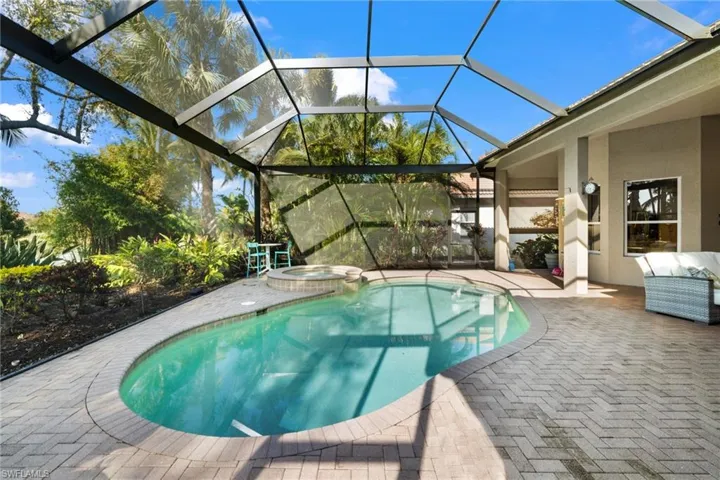 View of swimming pool featuring a lanai, an in ground hot tub, and a patio