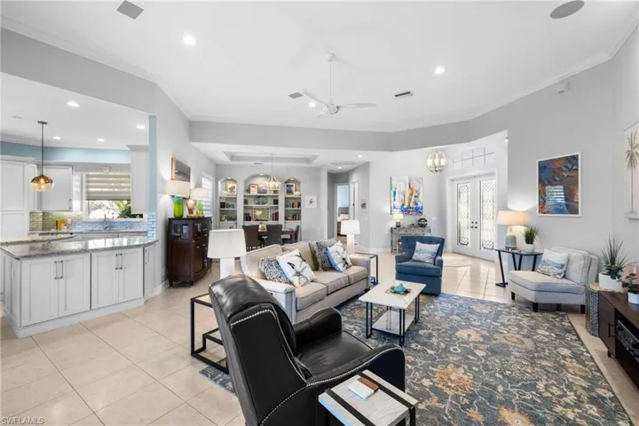 Living room featuring french doors, sink, crown molding, ceiling fan, and light tile patterned floors