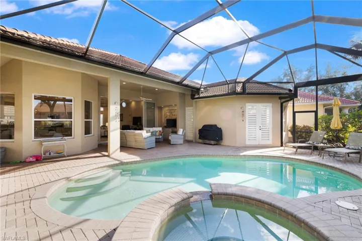 View of swimming pool with an in ground hot tub, an outdoor living space, glass enclosure, and a patio area