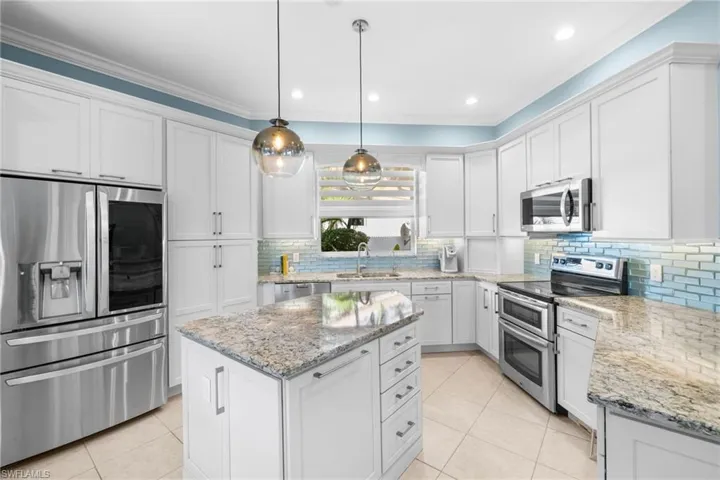 Kitchen with white cabinets, appliances with stainless steel finishes, and sink