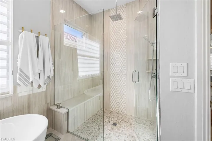 Bathroom featuring shower with separate bathtub