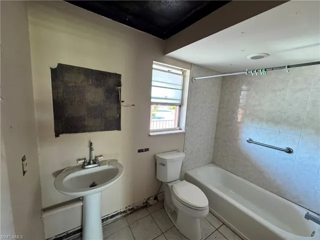 Bathroom featuring light tile patterned floors and tub / shower combination