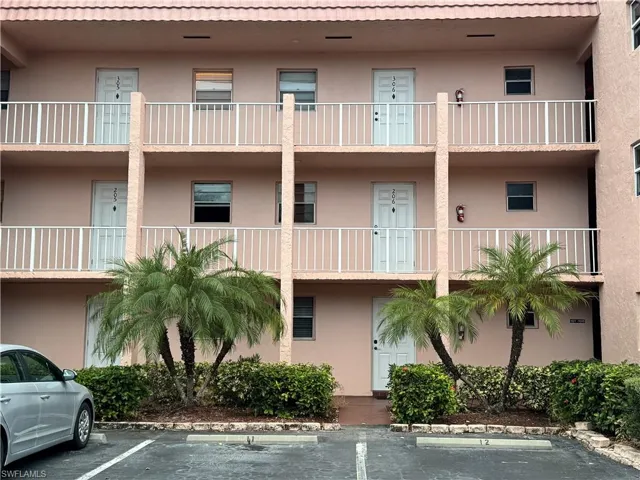View of apartment building / complex with uncovered parking