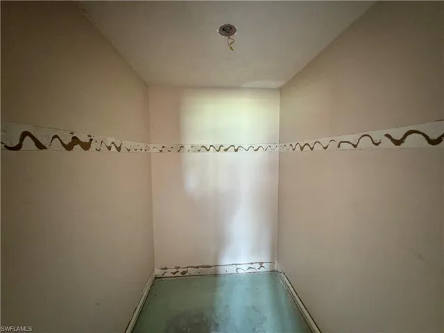 Unfurnished room featuring concrete flooring and baseboards