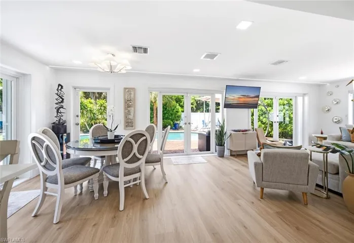 Dining area is wrapped in French doors leading out to the pool