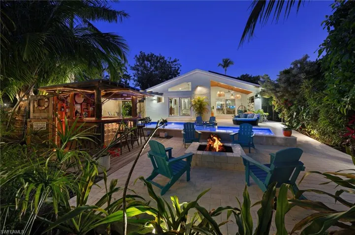Patio at night featuring a fire pit and a patio area