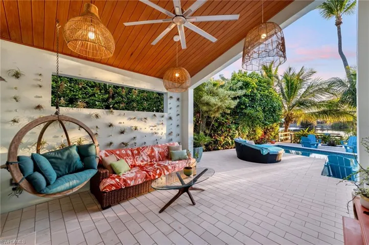 Patio terrace at dusk with a ceiling fan, a patio area, and an outdoor pool