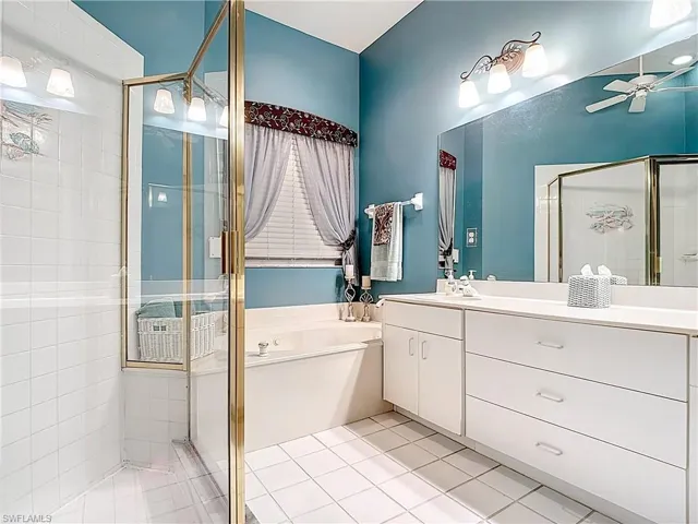 Full bathroom with vanity, a shower stall, a bath, and tile patterned floors