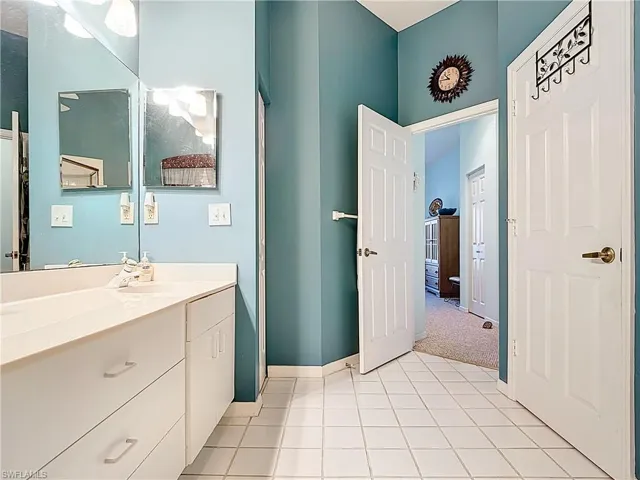 Bathroom with tile patterned floors, vanity, and baseboards
