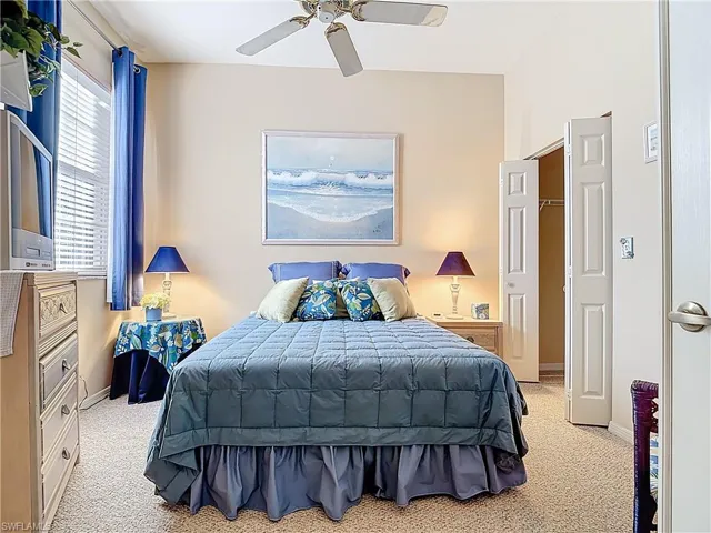 Bedroom featuring light colored carpet, a ceiling fan, and baseboards