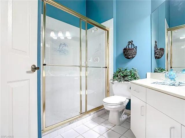 Bathroom featuring vanity, toilet, and a shower stall