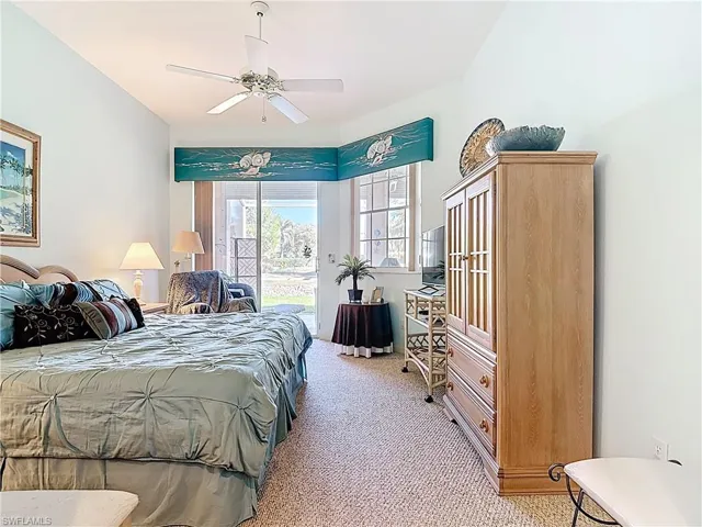 Bedroom with access to exterior, light colored carpet, and a ceiling fan