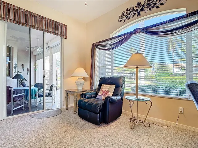 Sitting room with ceiling fan, baseboards, and carpet floors