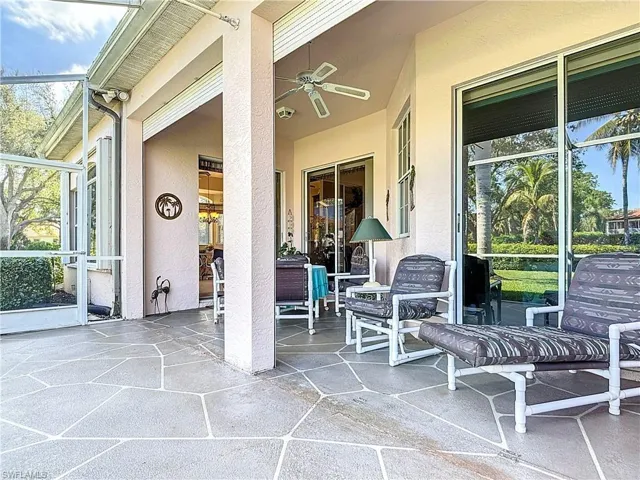 View of patio with glass enclosure and a ceiling fan