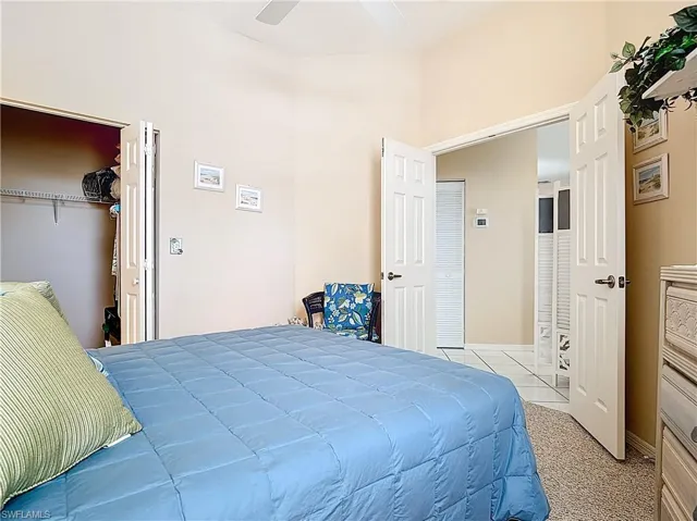Bedroom with carpet, a ceiling fan, and tile patterned flooring