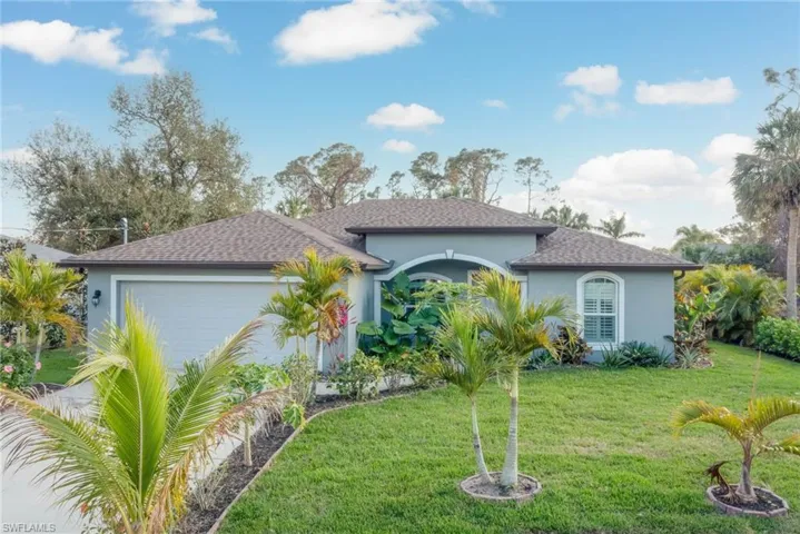 View of front of home featuring a garage and a front lawn